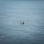 Dua nelayan berlayar dengan perahu tradisional di laut Bali